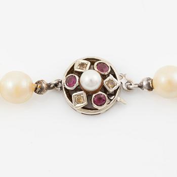 Necklace of cultured pearls with clasp in 18K gold set with white and red stones.