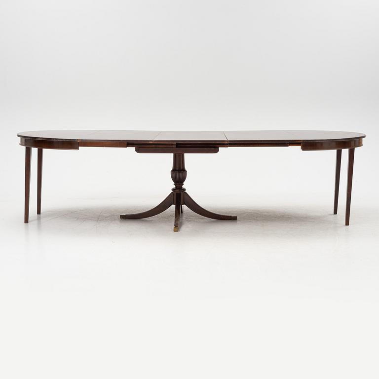 A round mahogany dining table with three additional leaves.