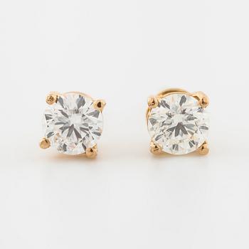 A pair of brilliant cut diamond earrings.