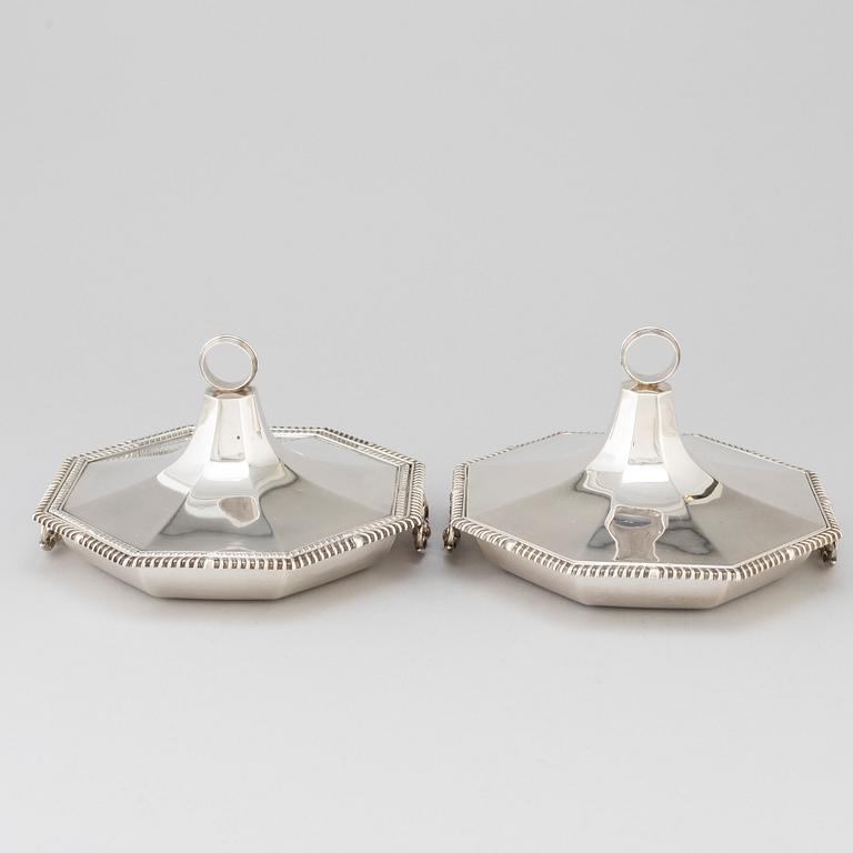 A matched pair of English silver dishes and covers, marked London 1910 and 1912.