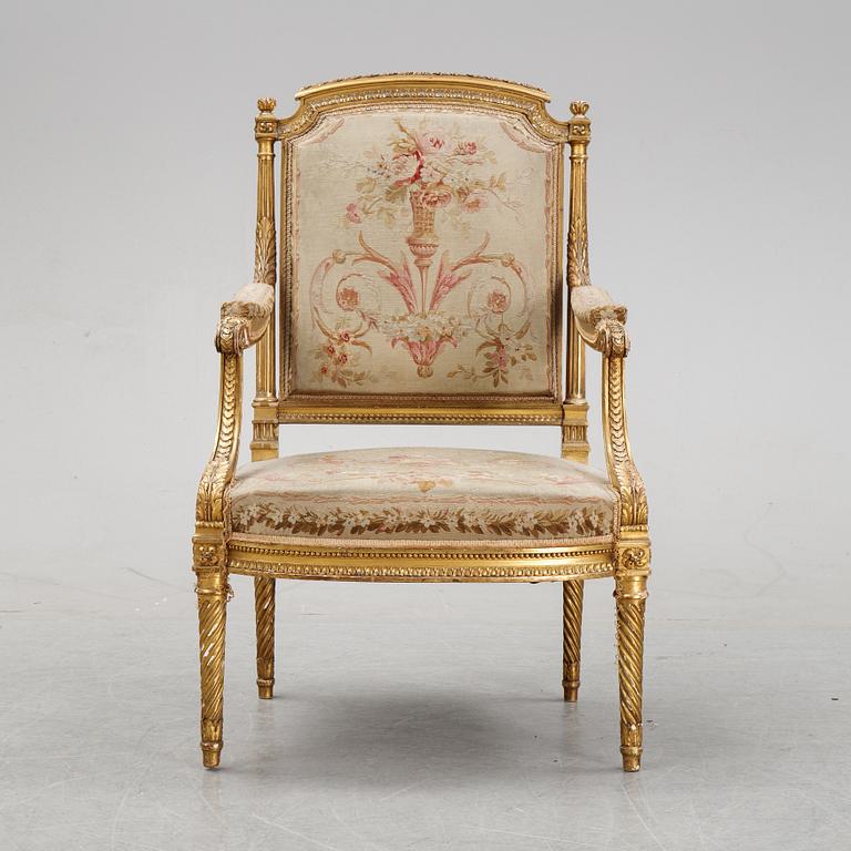 A gilt Louis XVI style armchair from around the year 1900.