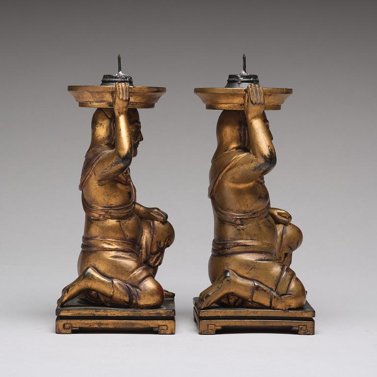 A pair of gilt lacquered candle holders, late Qing dynasty.