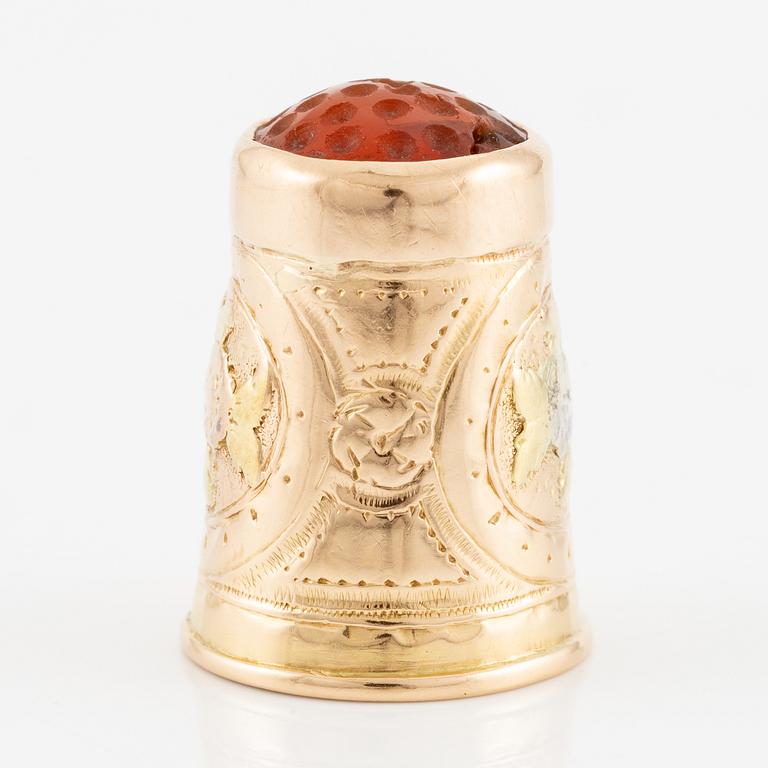 An 18K gold and carnelian thimble.