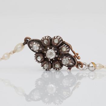 A possibly natural saltwater pearl necklace, clasp set with rose-cut diamonds.