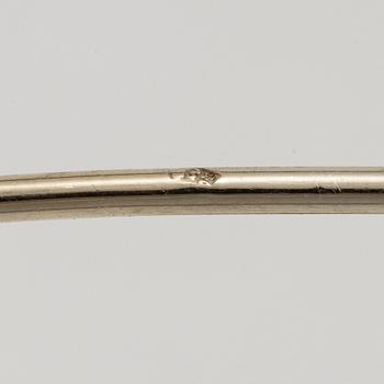 A brooch in platinum in the form of a bow with rubies and diamonds, likely from the 1950s.