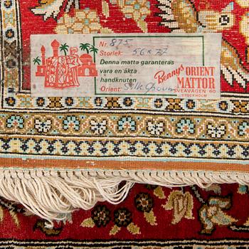 A silk rug from Qum, around 75 x 54 cm.
