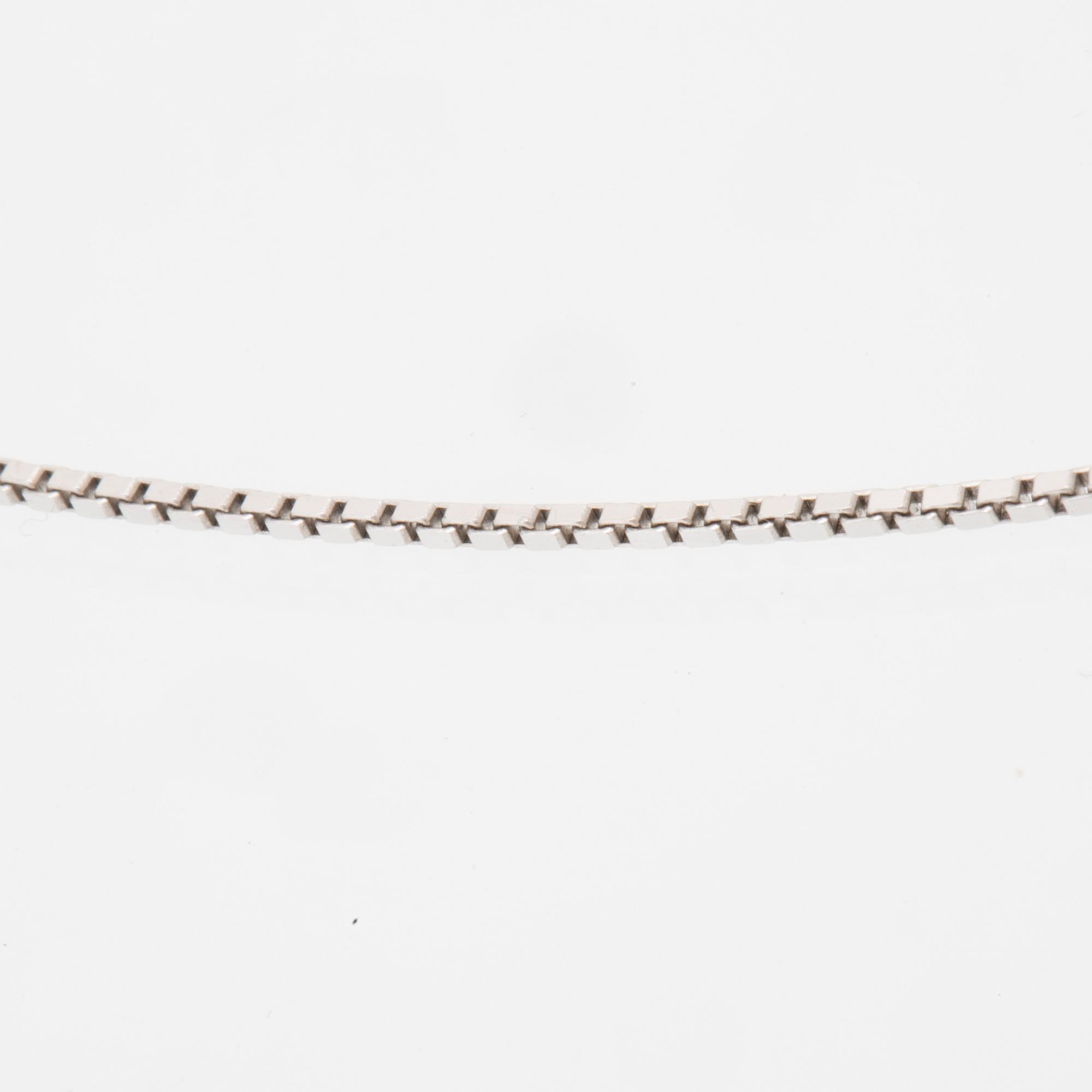 An 18K white gold necklace set with a drop-shaped cultured pearl and round brilliant-cut diamonds.