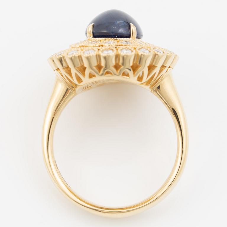Ring in 18K gold set with a cabochon-cut sapphire and brilliant-cut diamonds.