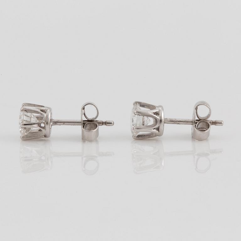 A pair of brilliant cut diamond earrings.