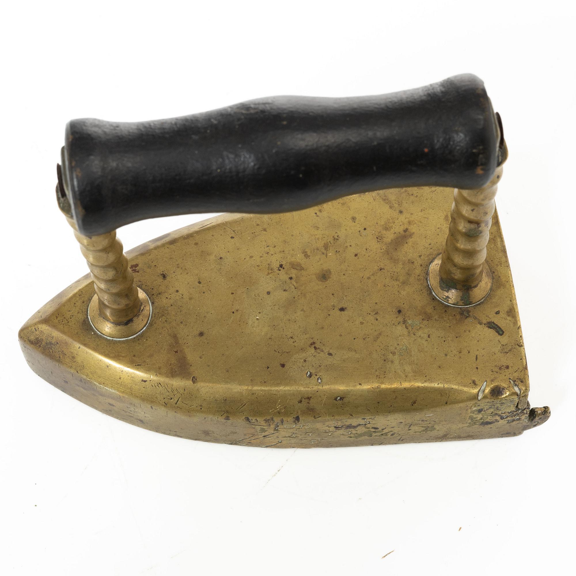 A brass clothes' iron, dated 1773.