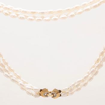 A necklace of cultured pearls set with a 14K gold lock and round brilliant cut diamonds.