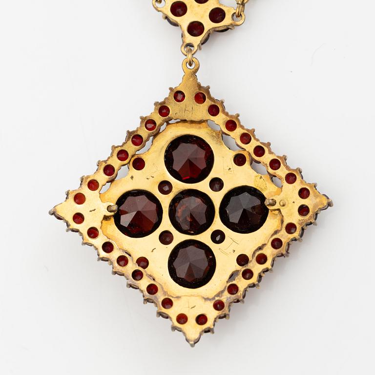 Pendant and a pair of earrings, gilt metal with garnets.
