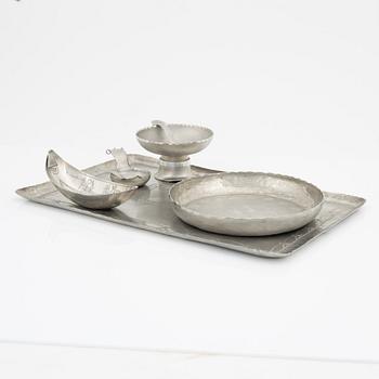 Four pewter bowls and a tray.