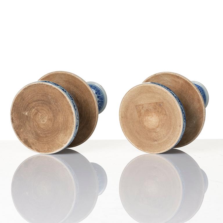 A pair of blue and white pricket candle sticks, with a poem, Qing dynasty with a Qianlong mark and of the period.