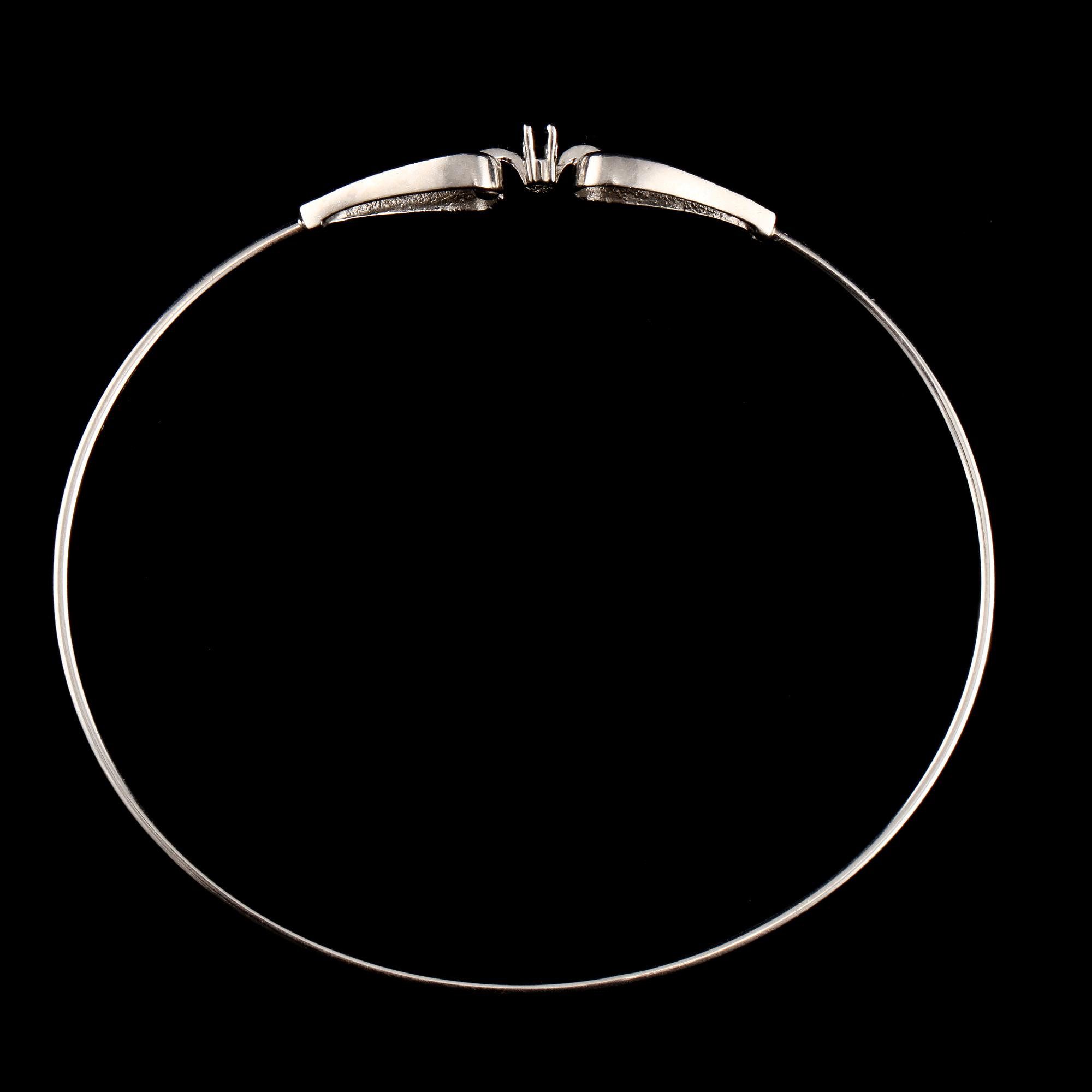 ARMRING, 18k vitguld med 2 åttkantslipade diamanter, 0.03 ct samt 2 fasettslipaded blå safirer. Vikt 6 g.
