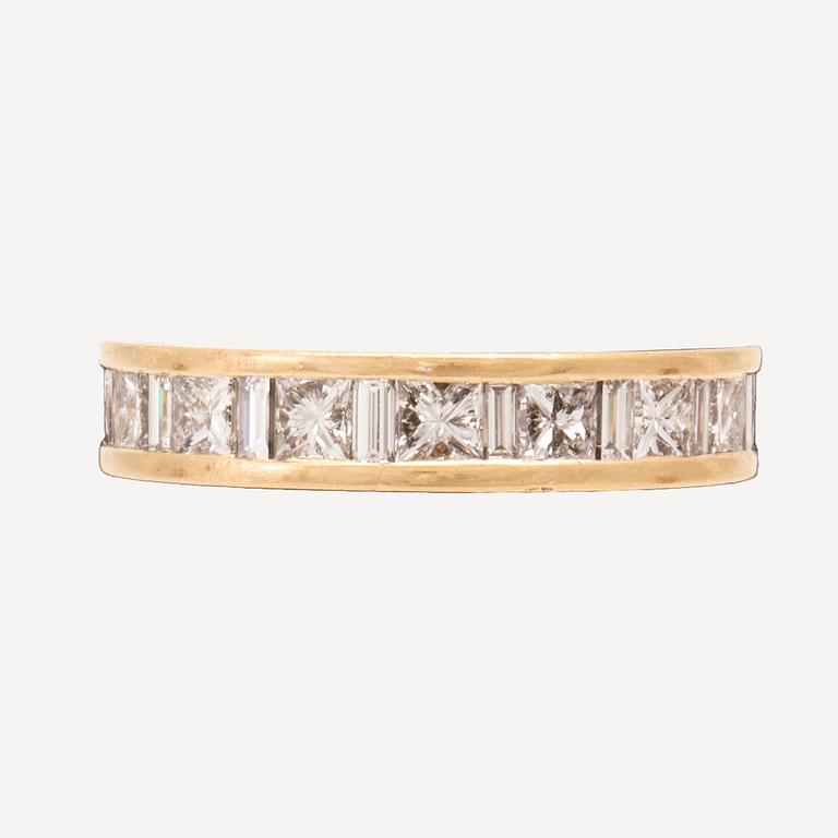 An 18K gold eternity ring set with baguette and princess cut diamonds by Hartmann's Denmark.