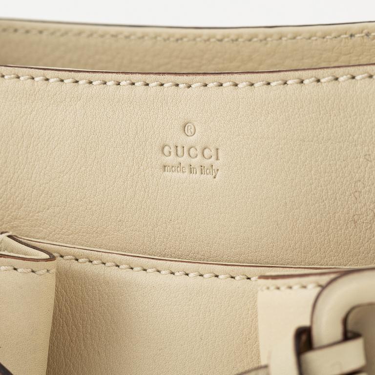 Gucci, a leather handbag.