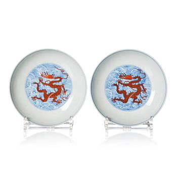 A pair of blue and white and iron red decorated dragon dishes, Qing dynasty with Qianlong mark.