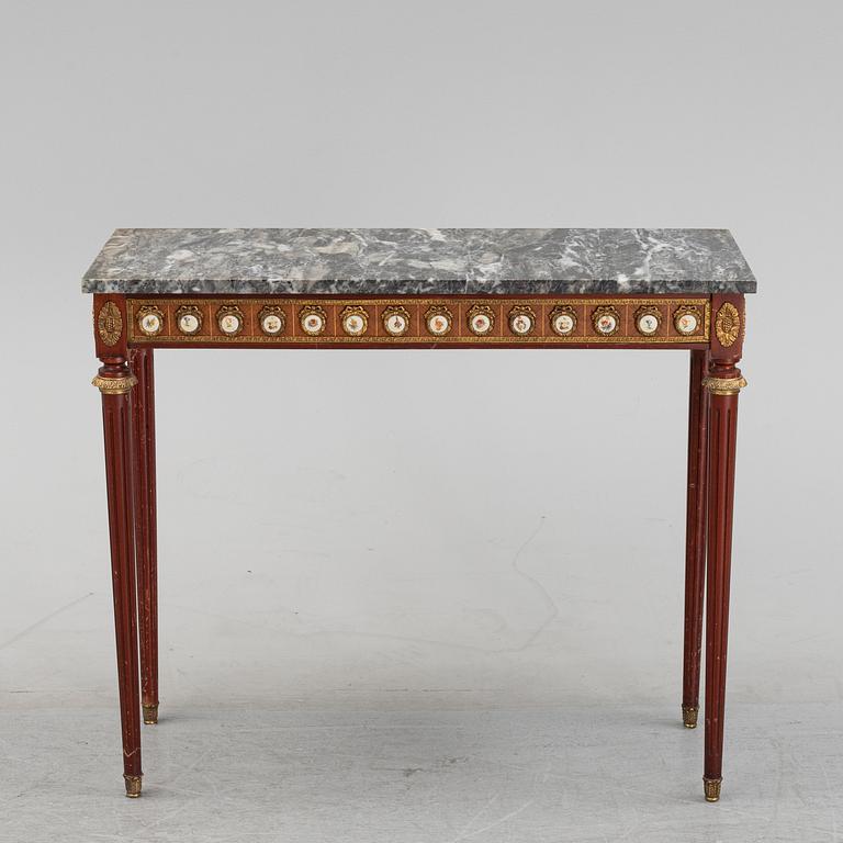 A Louis XVI style console table with a marble top.