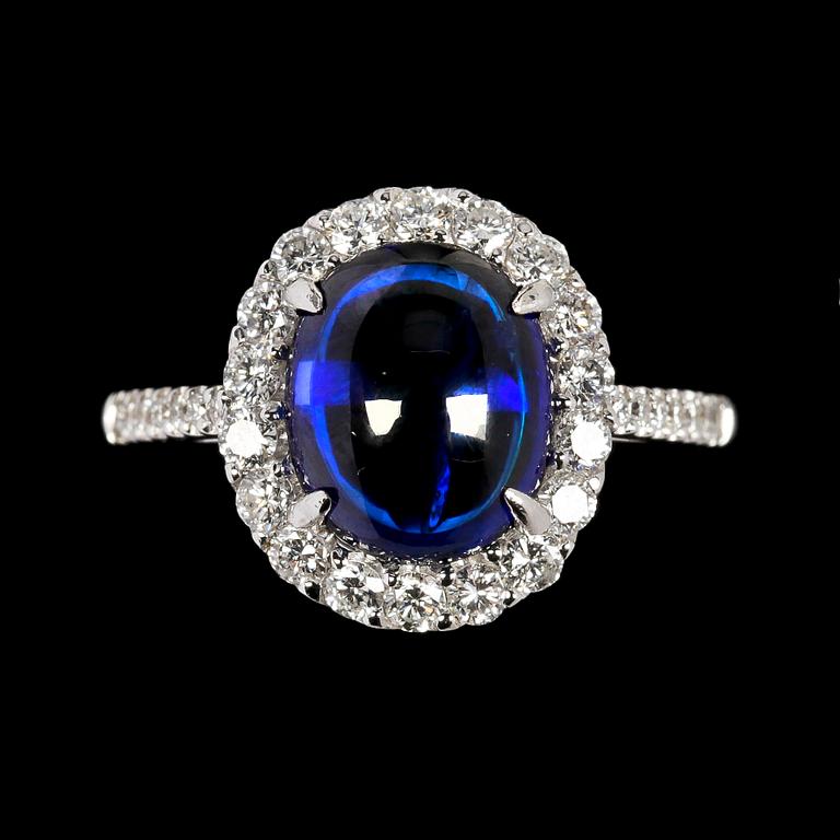 RING, cabochonslipad blå safir, 4.14 ct samt briljantslipade diamanter, tot. 0.68 ct.