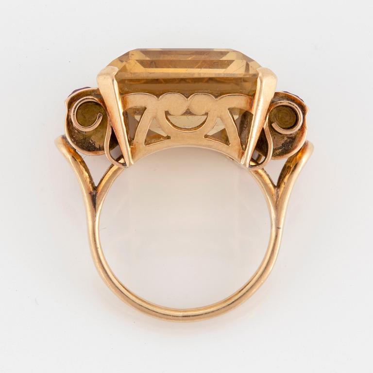 A 14K gold ring set with a faceted citrine and rubies.