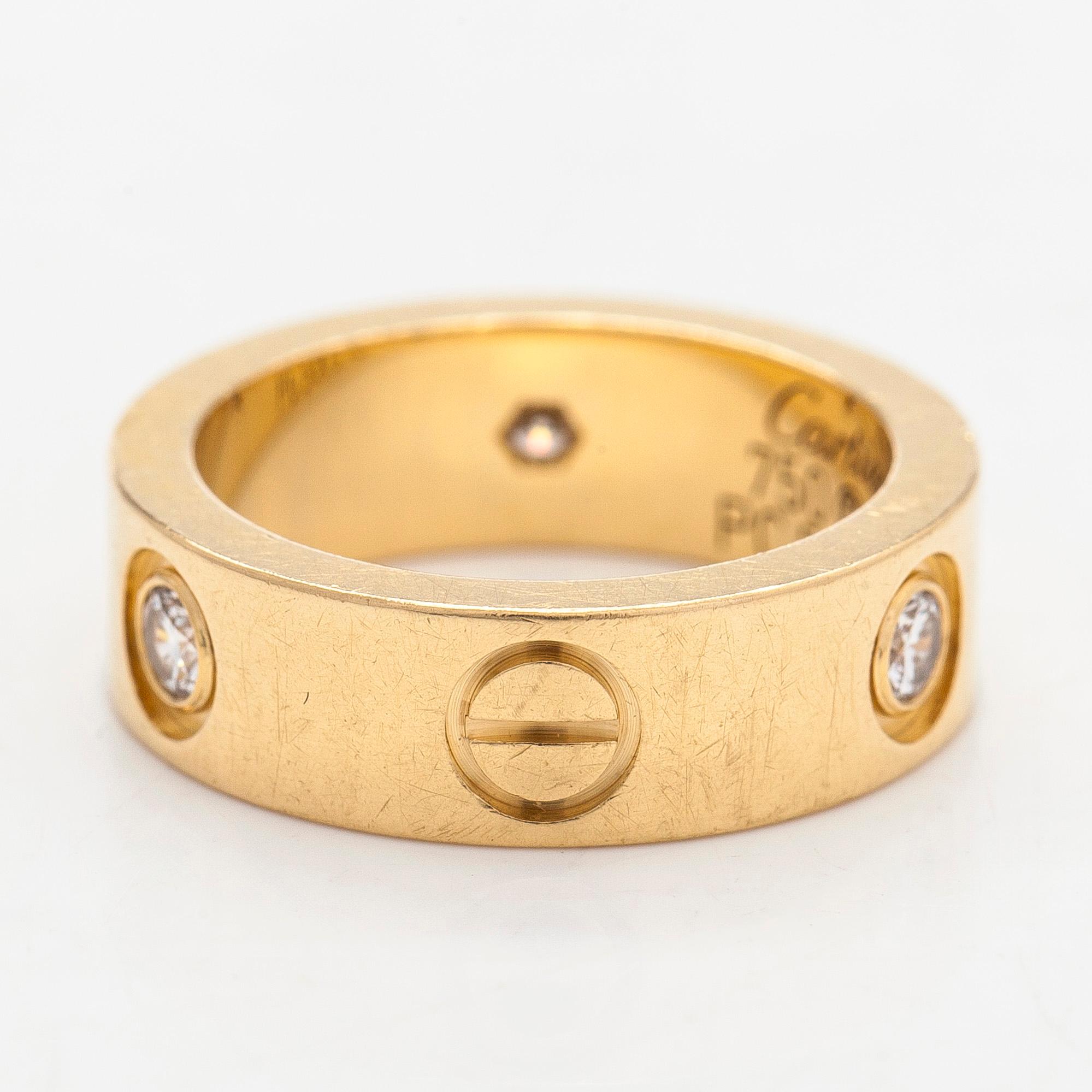 Cartier, an 18K gold 'Love' ring with three brilliant-cut diamonds.