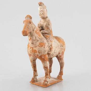 A painted pottery figure of an equestrian standard-bearer, Tang dynasty (618-907 AD.).