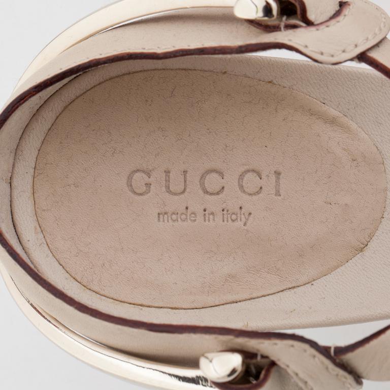 GUCCI, a pair of beige leather sandals.