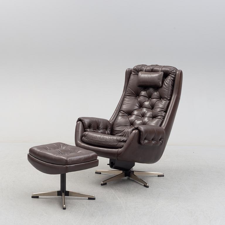 A leather upholstered easy chair with foot stool, 1960's/70's.
