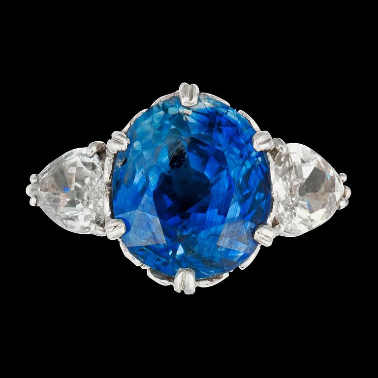 An untreated Ceylon sapphire, 8.14 cts, flanked by two pear shaped diamonds, ring.