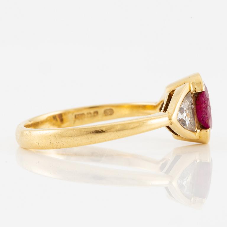 Ring 18K guld med en fasettslipad rubin samt två triangelformade briljantslipade diamanter.