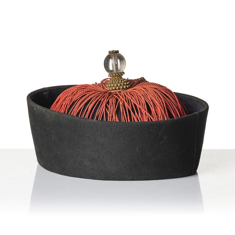 Two boxes with a mandarin's summer hat and black satin autumn hat and feather with six mandarin hat insignias.