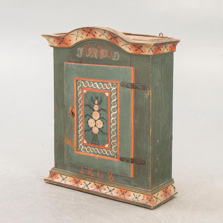 A painted Swedish wall cabinet dated 1808.