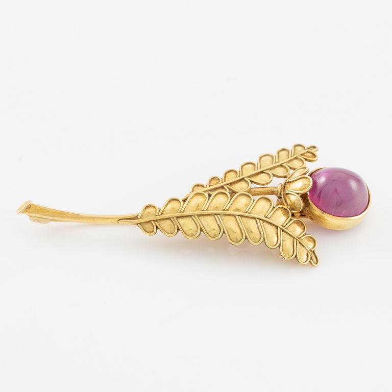 Brooch, 18K gold with cabochon-cut ruby, decoration of leaves.