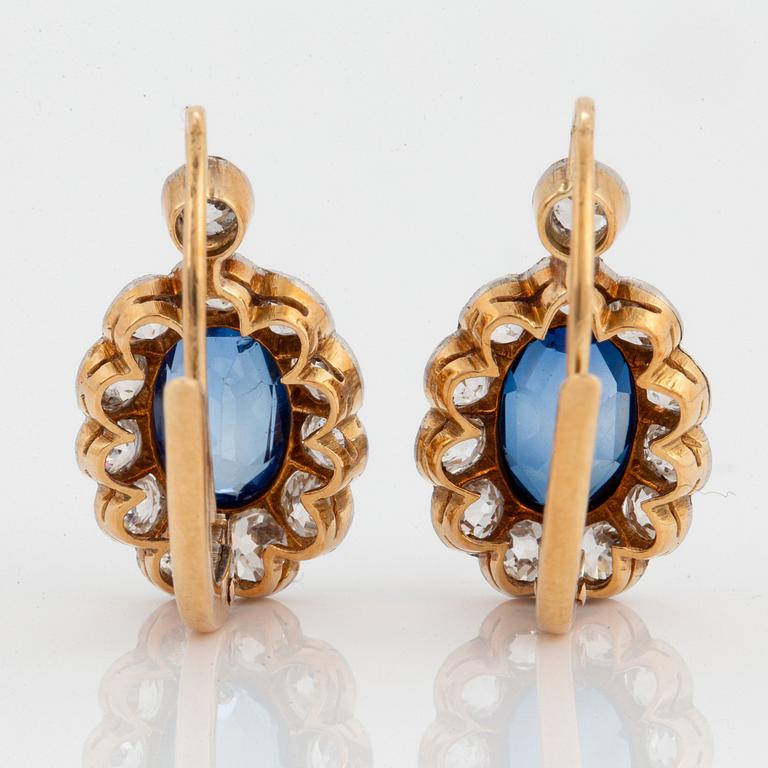 A pair of 14K gold and platinum earings set with faceted synthetic sapphires and old-cut diamonds.