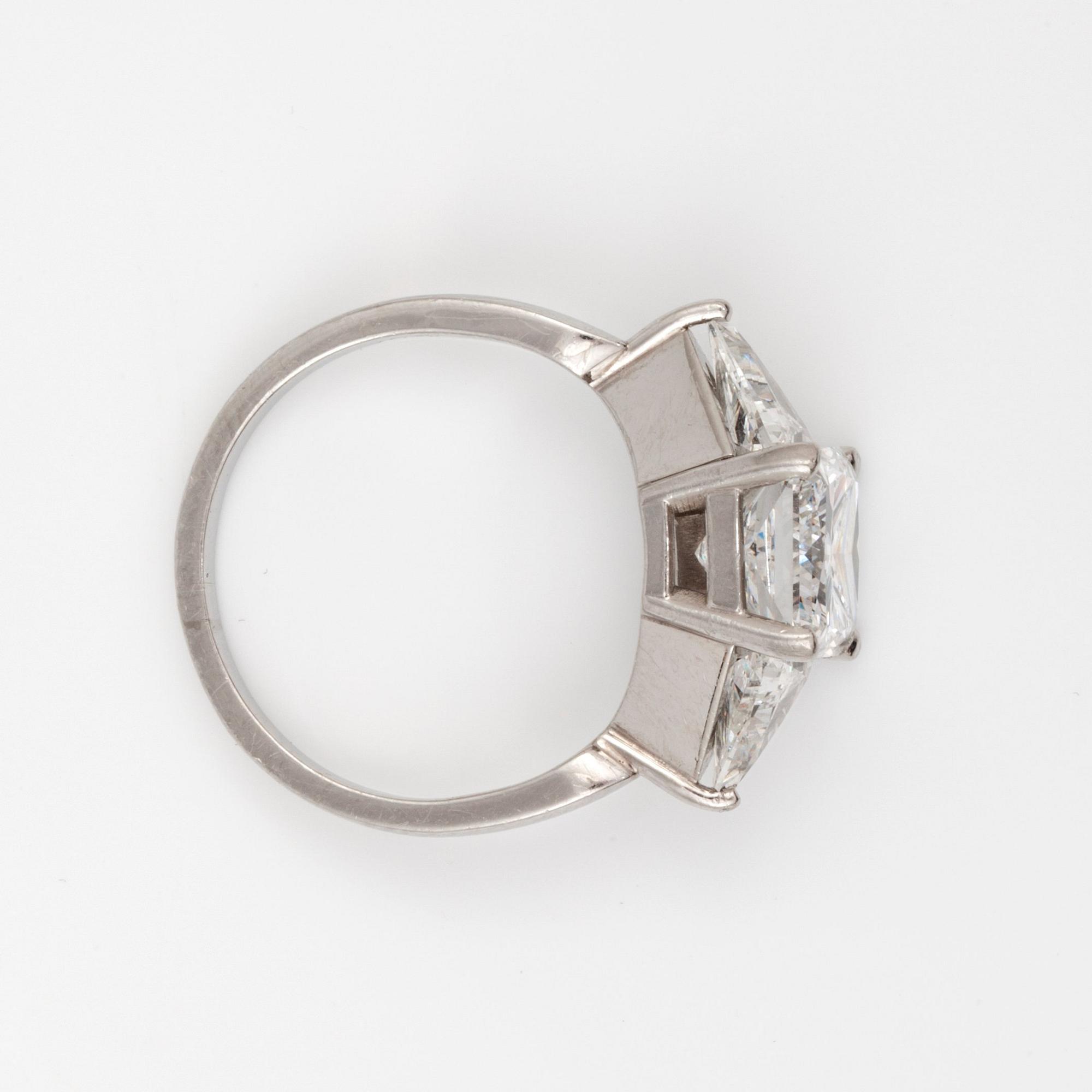 A radiant-cut diamond 3.01 cts ring. Flanked by two triangular cut diamonds, 0.50 ct each. E/VS2, certificate from HRD.