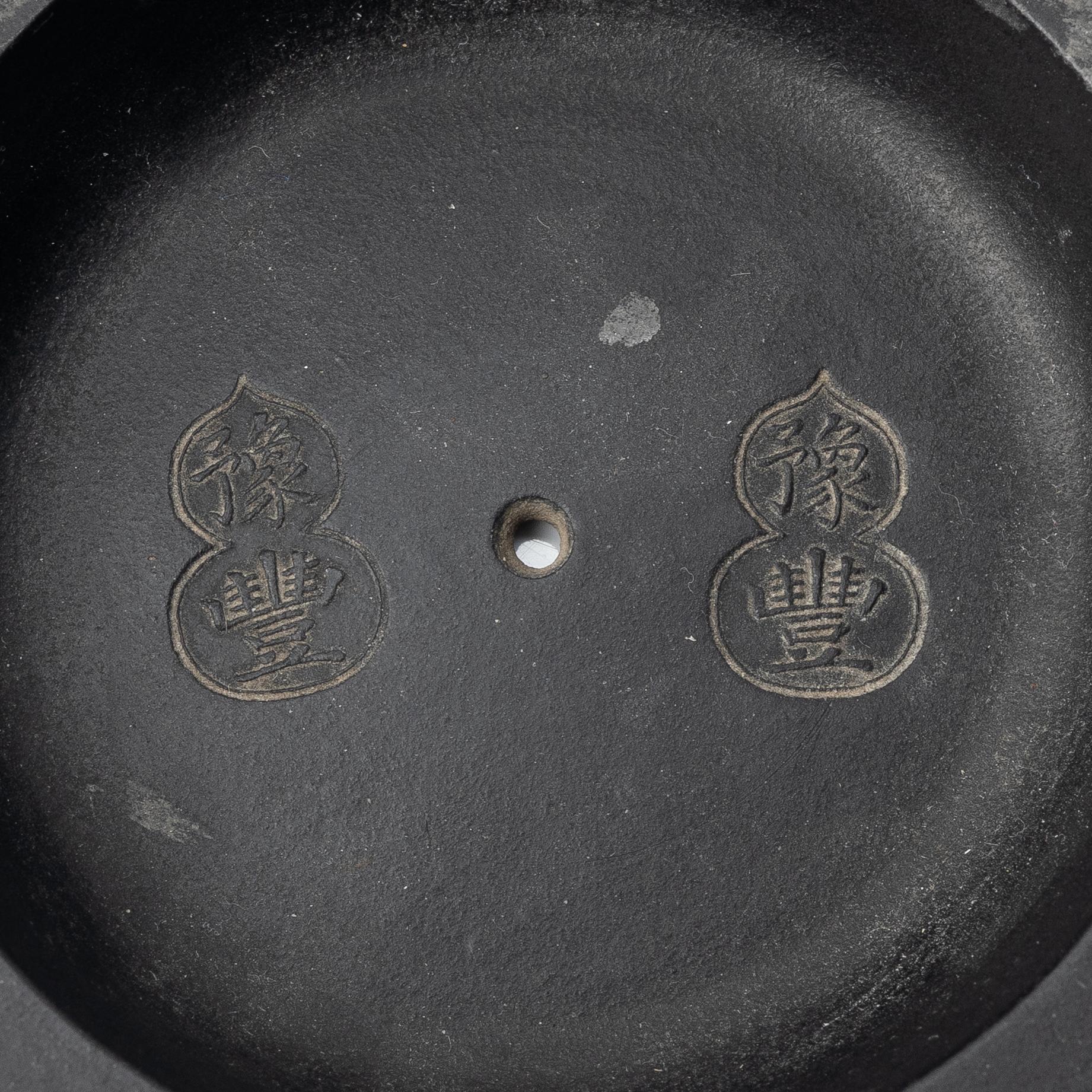 A dark yixing teapot, late Qing dynasty / early 20th century.