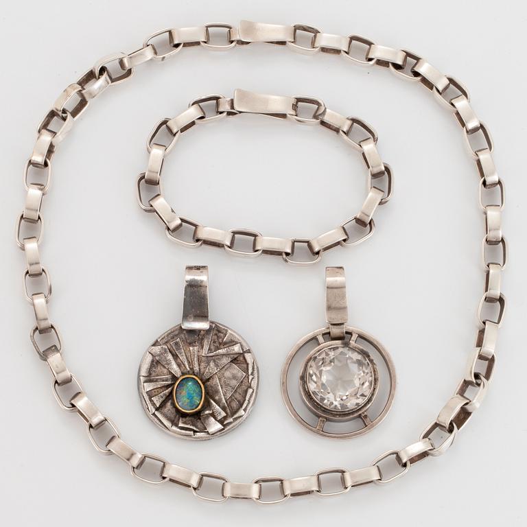 Sven Erik Högberg garnityr två hängen, ett armband och en collier.