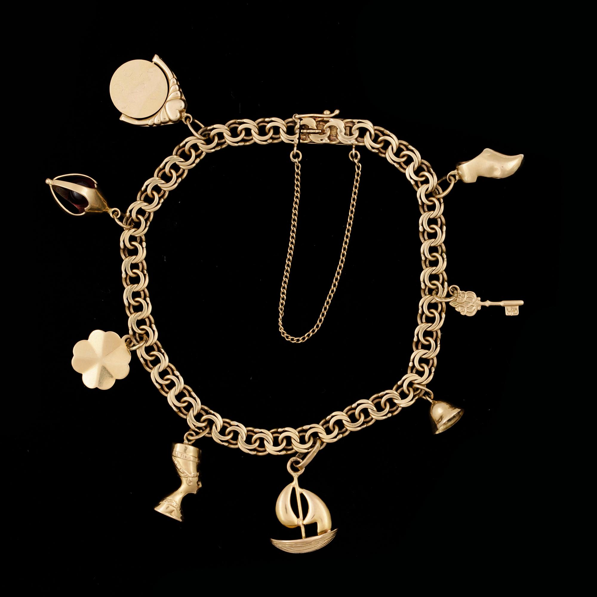 ARMBAND MED 8 BERLOCKER, 18k guld. Ahlberg & Berghman, Stockholm, 1951Vikt 15,7g.