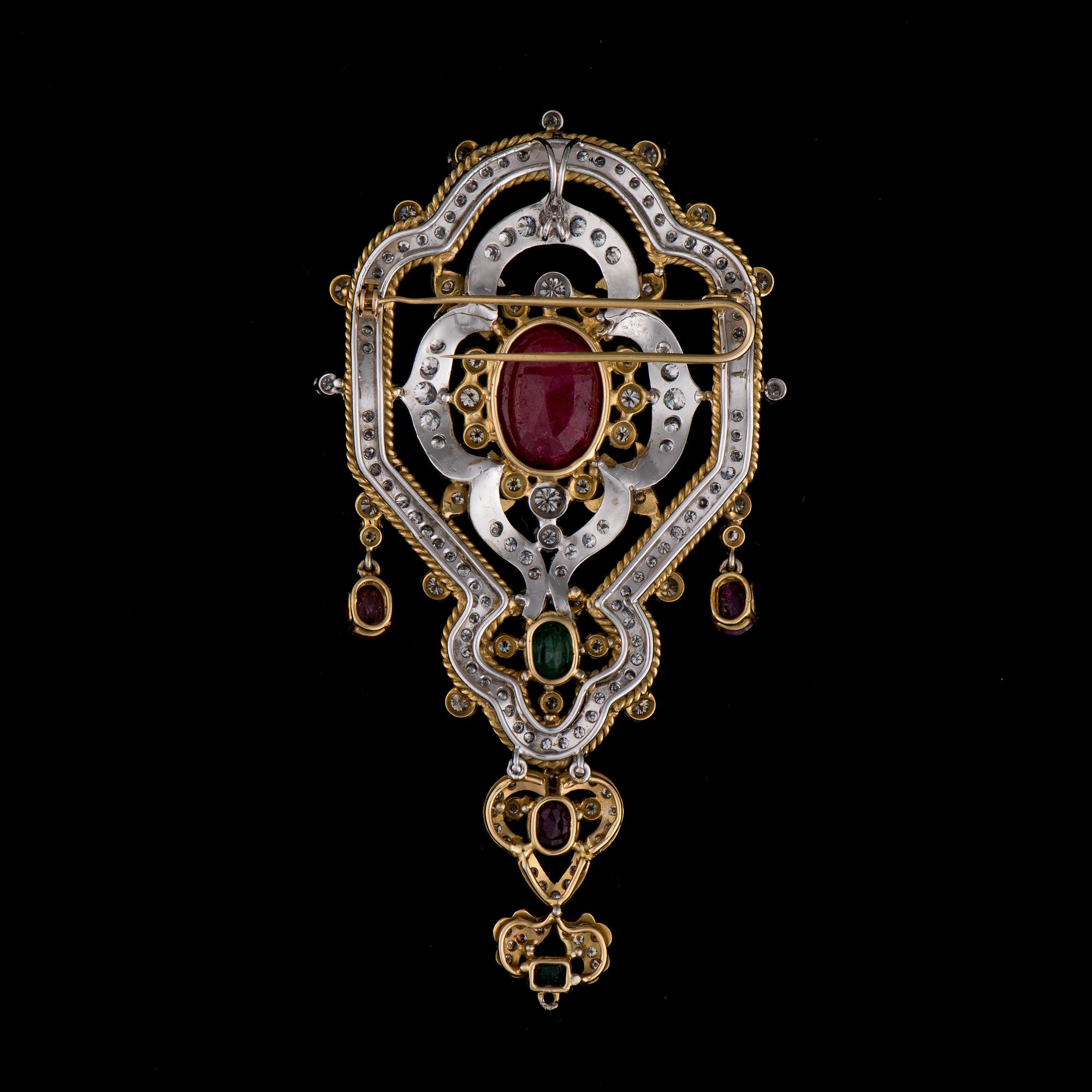 A BROOCH / PENDANT, 18K white and yellow gold, rubies, emeralds, diamonds. Iran. Weight c. 42,6 g.