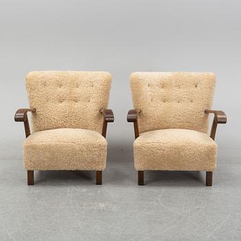 A pair of Danish lounge chairs with sheepskin upholstery.