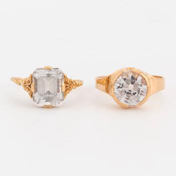 Two 18K gold rings set with synthetic, white spinels.