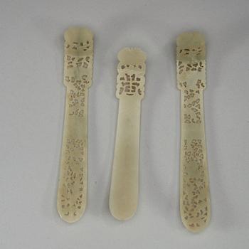 Three pale celadon carved nephrite hair adornments, late Qing dynasty (1644-1912).