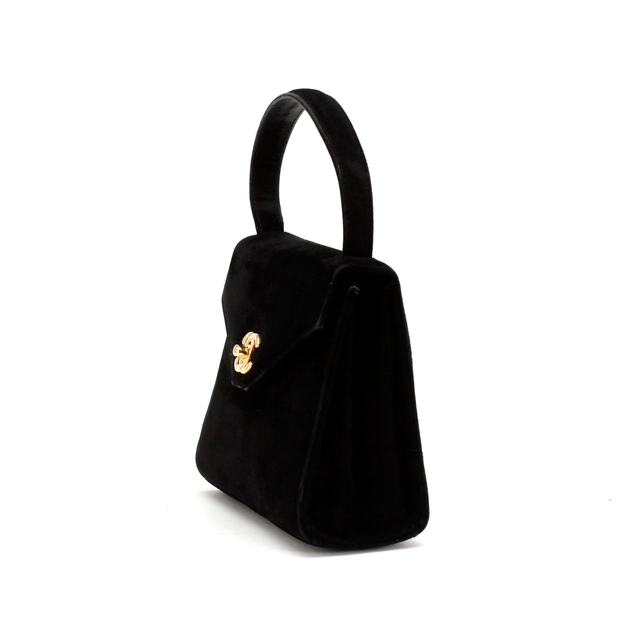 CHANEL, a black suede evningbag with a CC adorned lock.