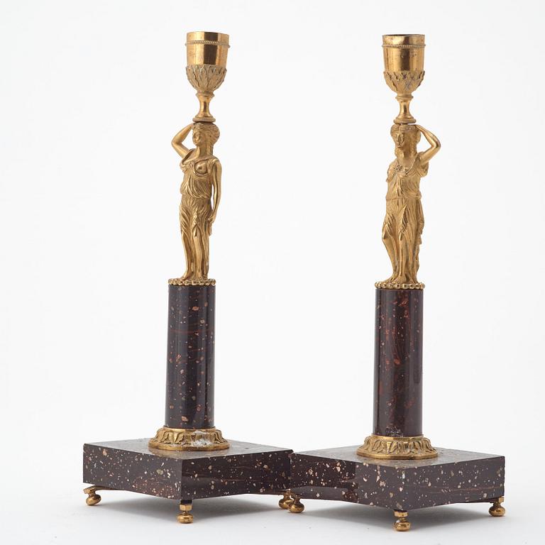 A pair of late gustavian early 19th century porphyry and ormolu candlesticks.