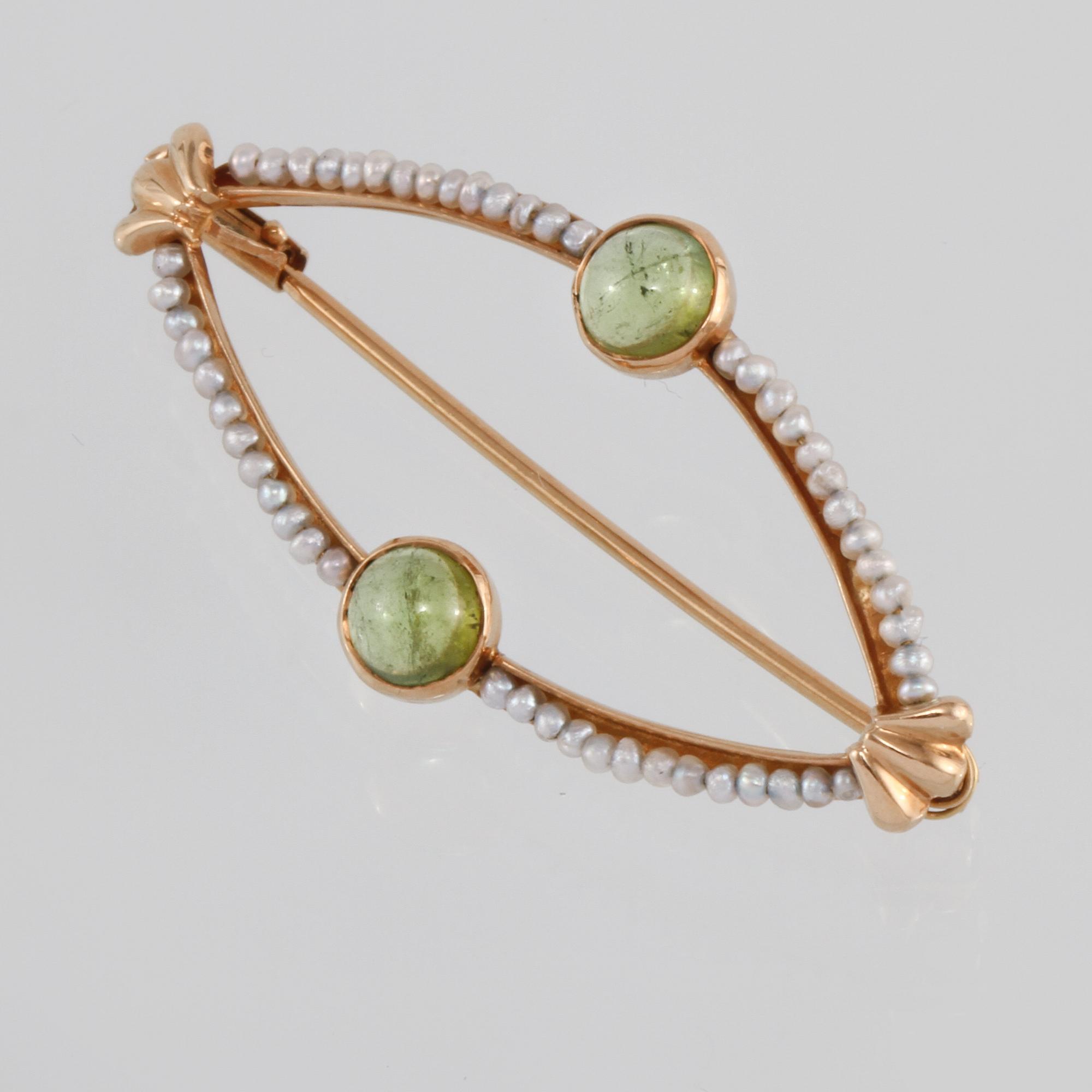 BROSCH, 18K guld med 2 cabochonlipade peridoter samt små odlade pärlor, Engelbert, Stockholm, 1956. Vikt 2,8 gram.