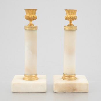 A pair of marble and gilt-bronze Louis XVI-style candelsticks, circa 1900.