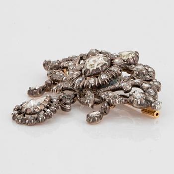 A silver brooch set with round brilliant-cut diamonds.