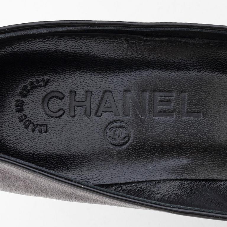 CHANEL, a pair of black leather pumps.