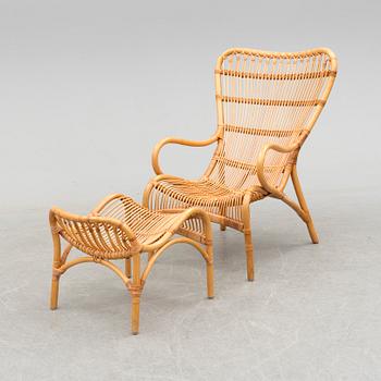 a rattan armchair with a stool from the late 20th century.